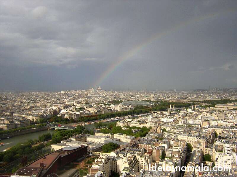 Vista do topo da Torre Eiffel: arco-íris lindo de presente nesse dia nublado.