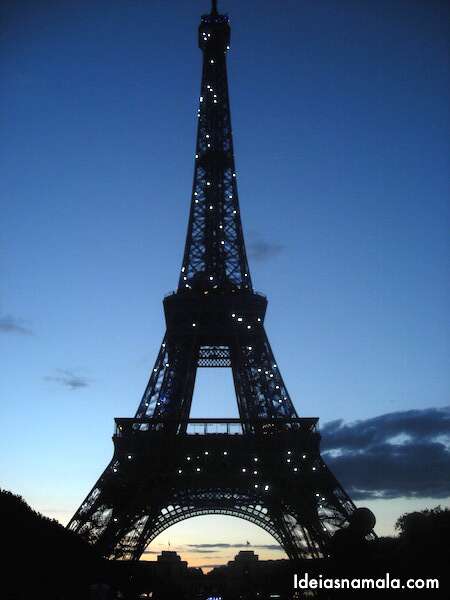 Torre Eiffel iluminada à noite em Paris: dica picnic ao entardecer. 