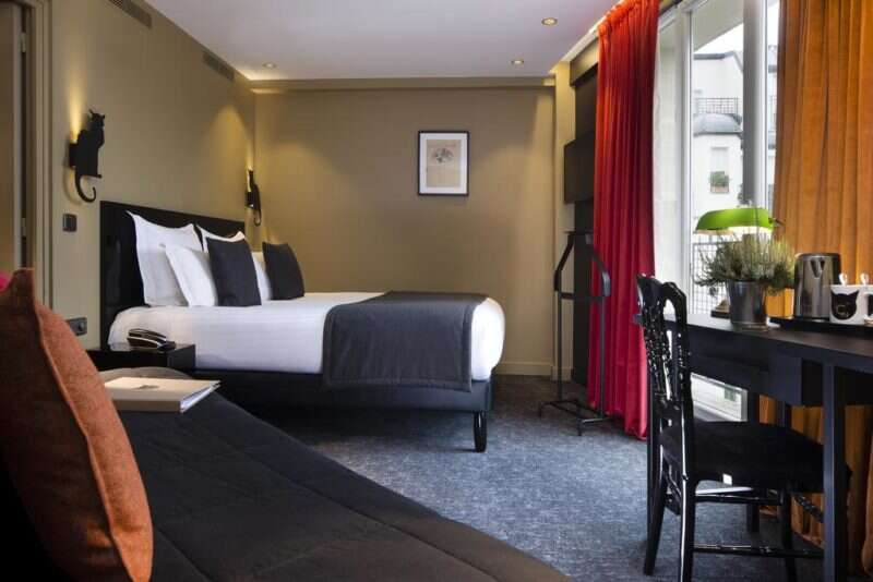 Onde ficar em Paris: quarto do Hotel Le Chat Noir. Decoração tons vermelhos e preto.